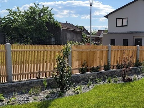 Quadratzaun aus Lärchenholz mit Granitpfosten in einem Neubaugebiet