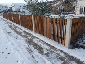 Quadratzaun aus Holz mit Granitpfosten in einem Neubaugebiet