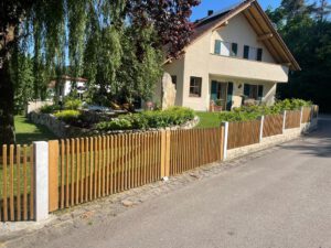 Quadratzaun aus Holz mit Granitpfosten und Tor